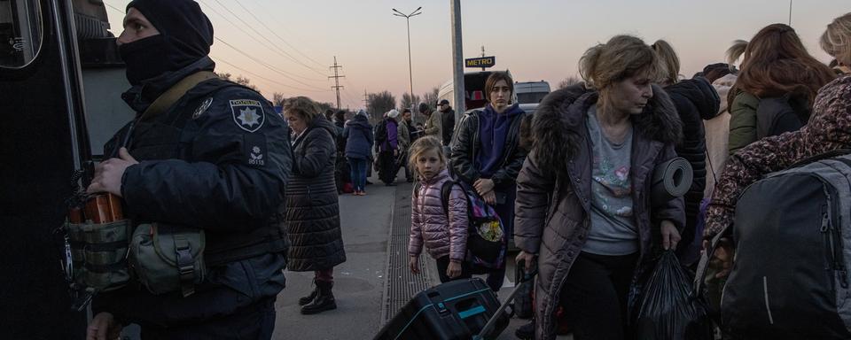 Des personnes ayant fui la ville de Marioupol, assiégée par l'armée russe, et Melitopol occupée, se rassemblent après leur arrivée au point d'évacuation de Zaporizhzhia, en Ukraine. [EPA - Roman Pilipey]