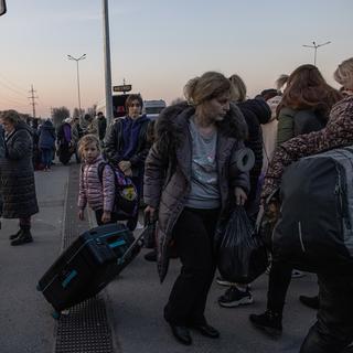 Des personnes ayant fui la ville de Marioupol, assiégée par l'armée russe, et Melitopol occupée, se rassemblent après leur arrivée au point d'évacuation de Zaporizhzhia, en Ukraine. [EPA - Roman Pilipey]