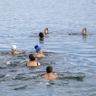 Des personnes nageant dans le Léman à moins de 15 degrés. [Keystone - Martial Trezzini]