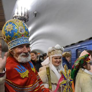 Des ukrainiens du collectif 'Kyivska Kolyada' chantent des chants de Noël et collectent de l'argent pour l'armée dans le métro de Kyiv le 25 décembre 2022. [EPA/Keystone - Oleg Petrasyuk]