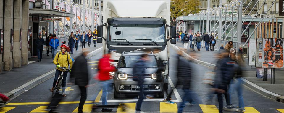 Des voitures attendent a un passage piétons alors qu'elles traversent le Grand-Pont, peu après sa réouverture le 3 décembre 2022. [Keystone - Valentin Flauraud]