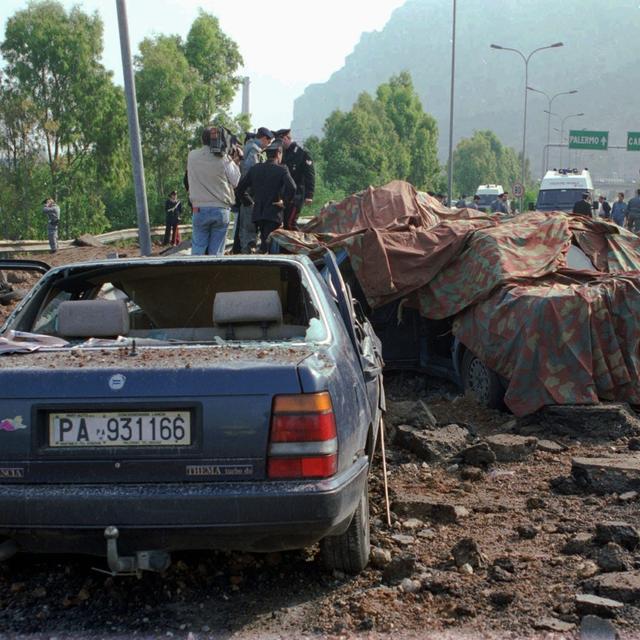 L'attentat contre le juge Falcone, le 23.05.1993 avait détruit plusieurs véhicules. [AP/Keystone - Bruno Mosconi]