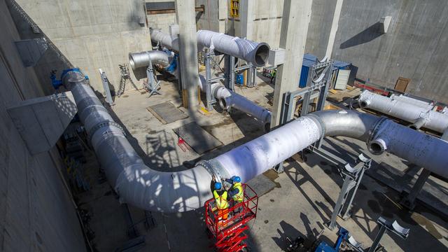 Des ouvriers travaillent à l'installation de conduites d'eau sur la chantier Genilac des SIG à la station de pompage du Vengeron (GE). [Keystone - Salvatore Di Nolfi]