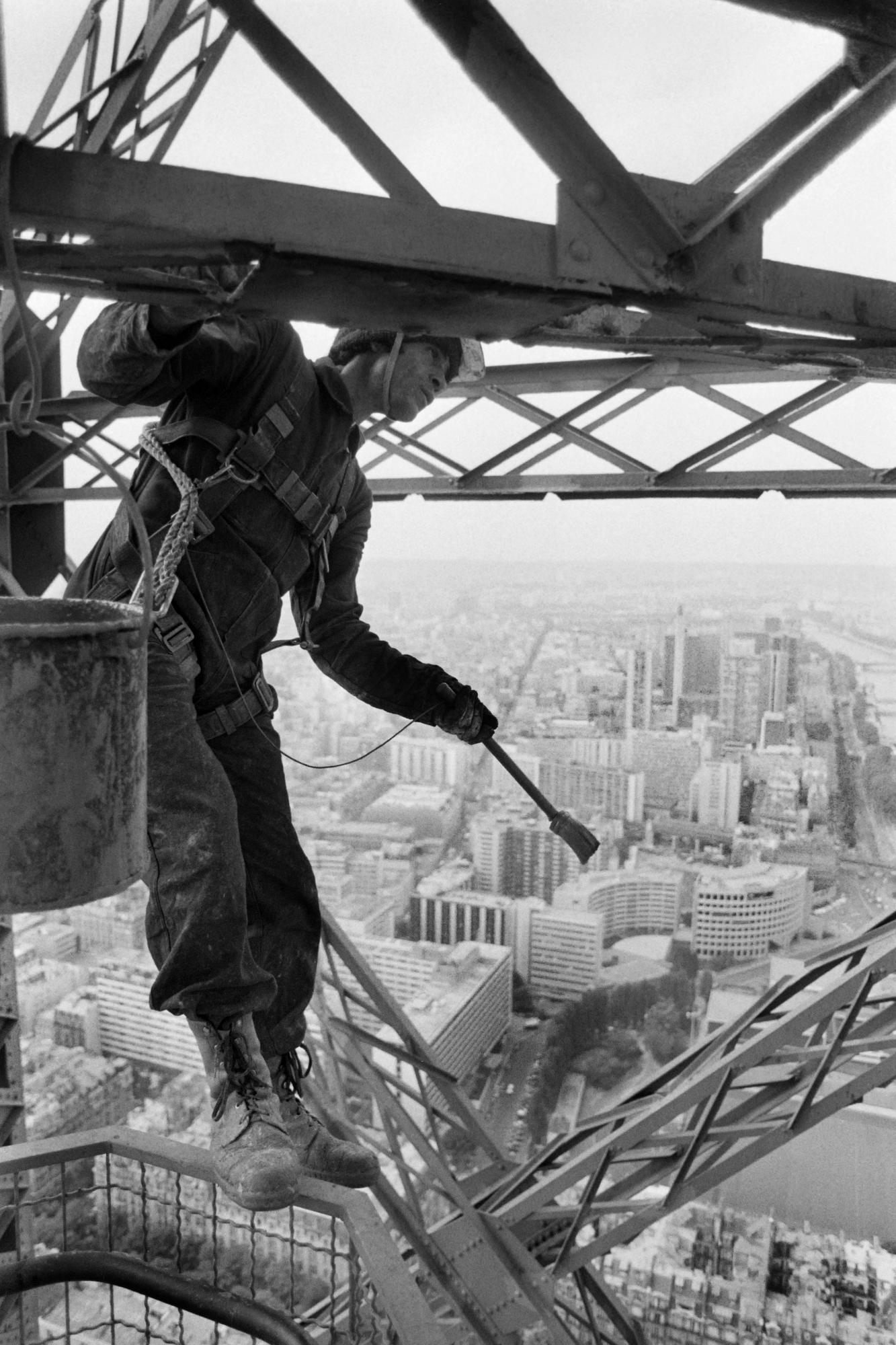 Un ouvrier repeignant la Tour Eiffel en 1983. [AFP - PHILIPPE WOJAZER]