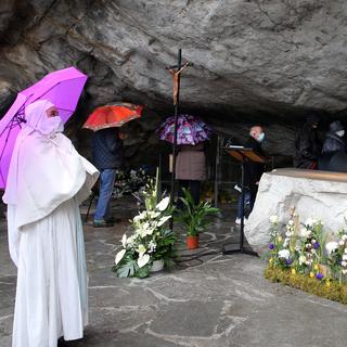 Des personnes en pélerinage à la chapelle catholique de Lourdes, en France. [Keystone/AP Photo - Bob Edme]