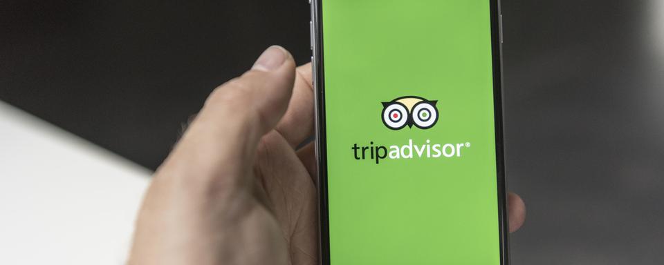 Le logo de l'application TripAdvisor sur un smartphone. [Keystone - Christian Beutler]