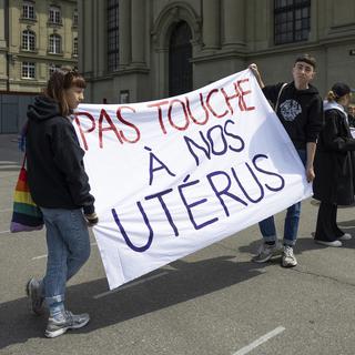 Des participants à un rassemblement sur le droit à l'avortement tiennent des pancartes, le samedi 7 mai 2022, à Berne. [Keystone - Peter Klaunzer]