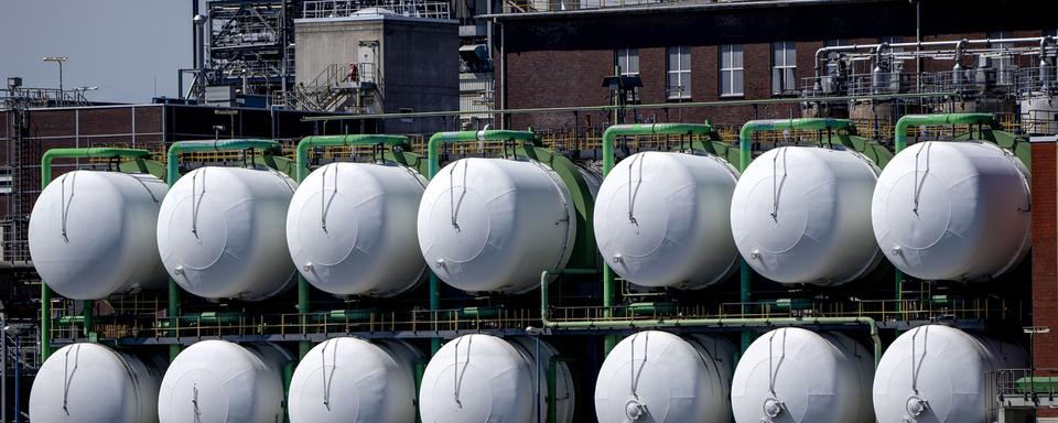 Des réservoirs sont fixés sur un bâtiment au sol de l'usine chimique BASF à Ludwigshafen, en Allemagne, lundi 4 juillet 2022. [AP Photo/KEYSTONE - Michael Probst]