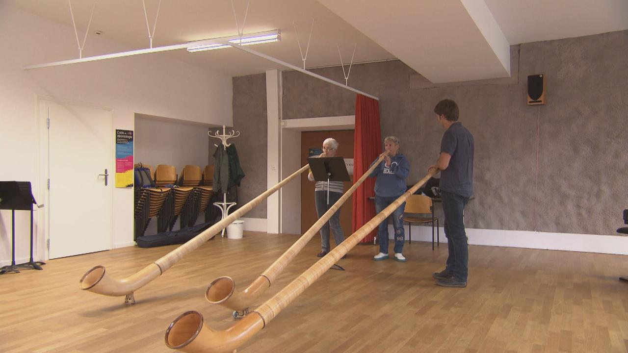 Les deux élèves du Conservatoire neuchâtelois Caroline de Montmollin (gauche) et Catherine Aeschlimann sous l'oreille attentive de leur professeur de cor des Alpes, Valentin Faivre. [RTS]