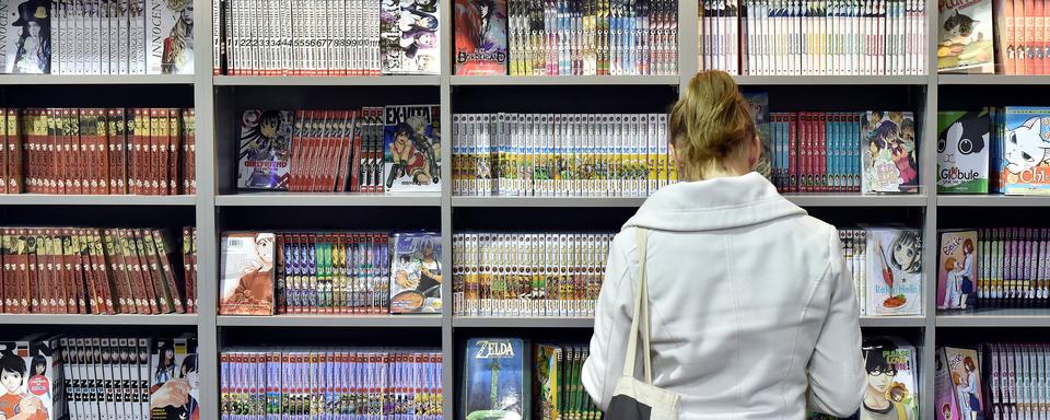 Une lectrice de mangas lors de la 43e édition du festival de BD d'Angoulême en 2016. [AFP - Georges Gobet]