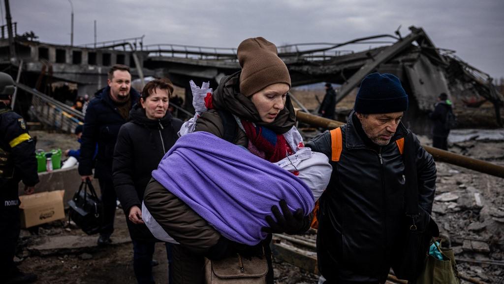 Une mère et son bébé en train de fuir la ville d'Irpin, au nord de Kiev. [AFP - Dimitar Dilkoff]