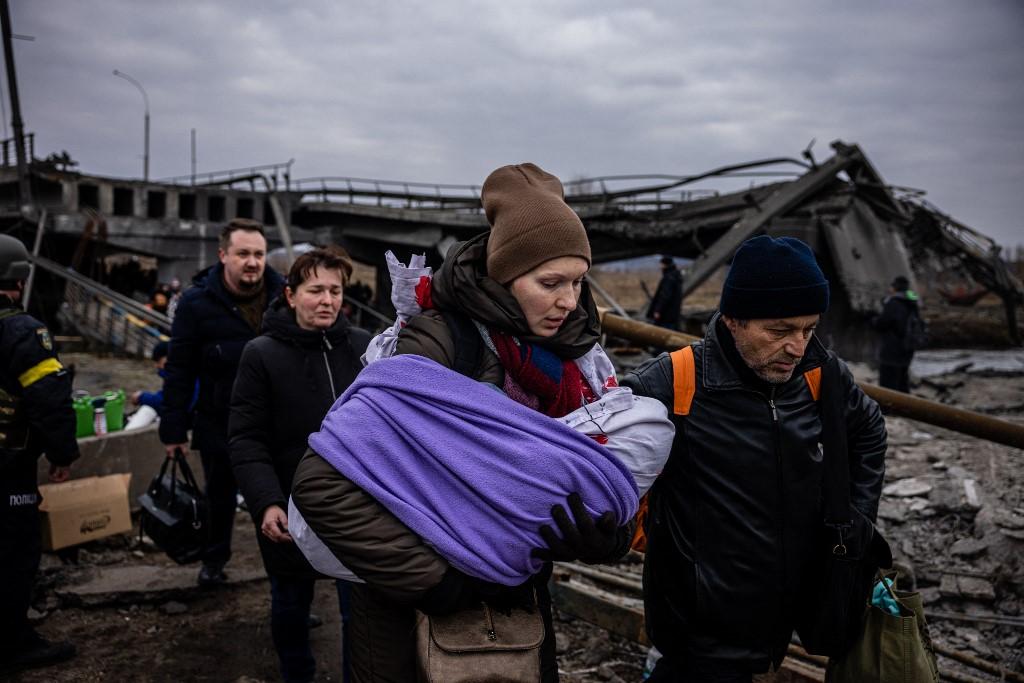 Une mère et son bébé en train de fuir la ville d'Irpin, au nord de Kiev. [AFP - Dimitar Dilkoff]