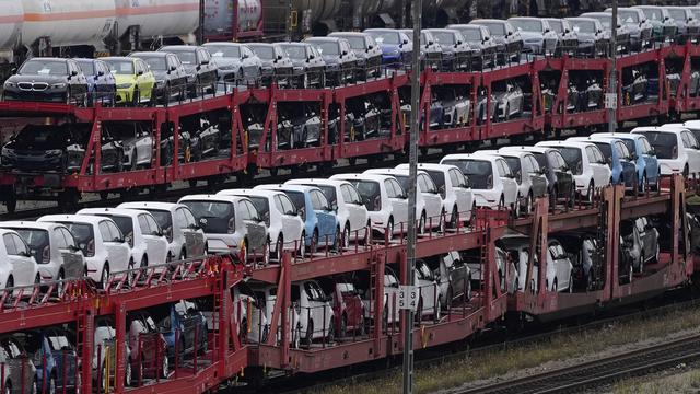 Des voitures neuves attendent dans une gare allemande. [Keystone/AP Photo - Matthias Schrader]