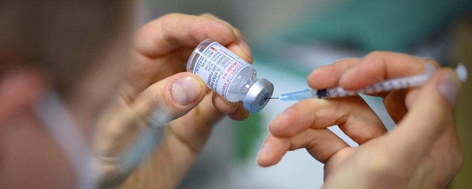 Un préparateur remplit une seringue avec vaccin de Moderna contre le Covid-19 là Montreux le 26 avril 2021. [Laurent Gillieron]