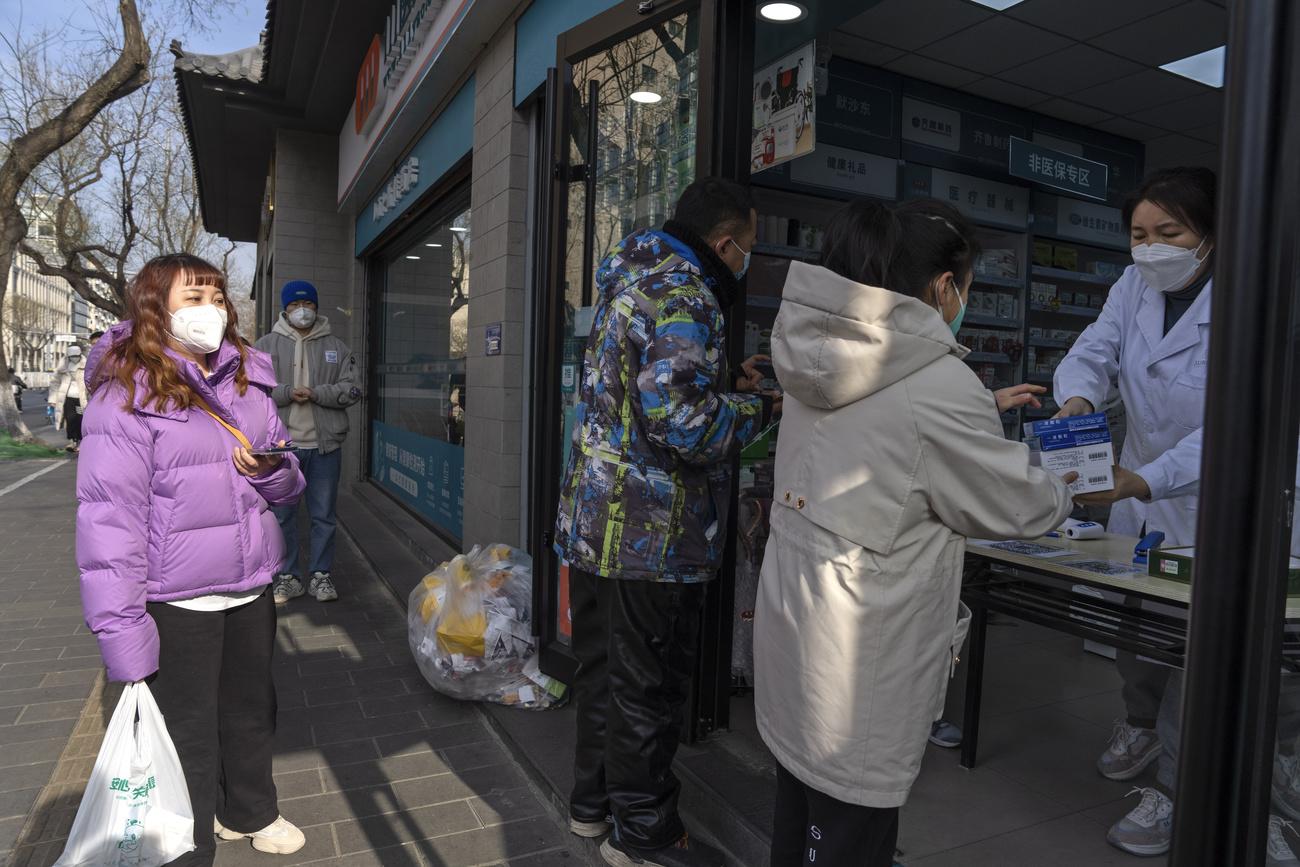 Des habitants de la capitale Pékin font la queue devant une pharmacie, le 09 décembre 2022. [Keystone - AP Photo/Ng Han Guan]