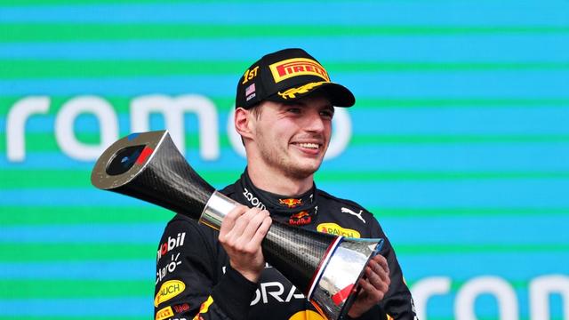 Max Verstappen, tout sourire, soulève le trophée du vainqueur. [Peter Fox]