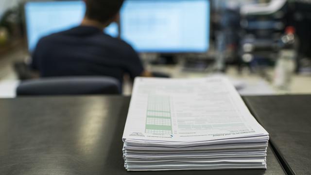 Une pile de déclarations d'impôts au bureau des impôts de Glattfelden, prise le 22 janvier 2015. [KEYSTONE - Christian Beutler]