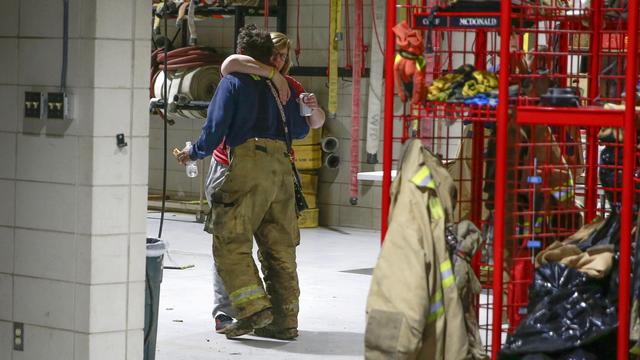 Deux membres du service d'incendie de Winterset s'embrassent après une longue soirée à répondre aux appels d'urgence suite à la tornade [The Des Moines Register via AP) - Bryon Houlgrave]