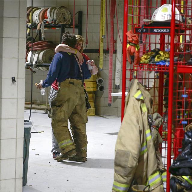 Deux membres du service d'incendie de Winterset s'embrassent après une longue soirée à répondre aux appels d'urgence suite à la tornade [The Des Moines Register via AP) - Bryon Houlgrave]