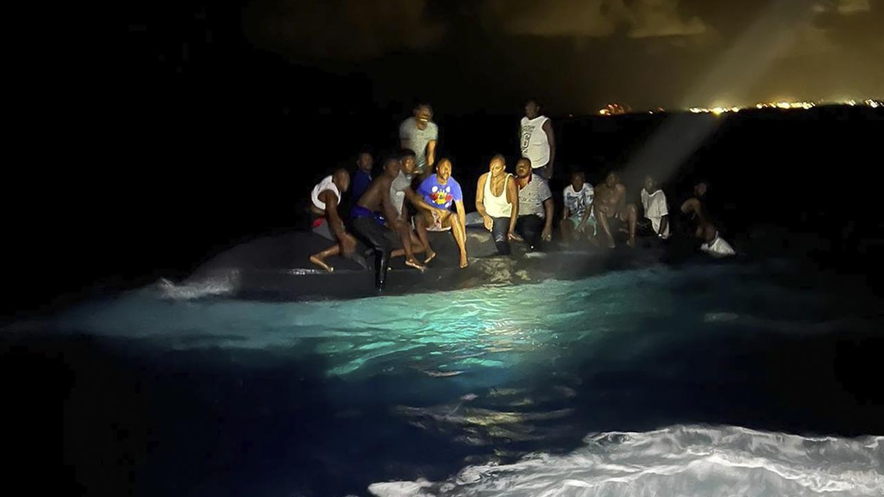 Des survivants haïtiens sont assis sur un bateau chaviré alors qu'ils sont sur le point d'être secourus,  tôt le dimanche 24 juillet 2022. [Royal Bahamas Defense Force]