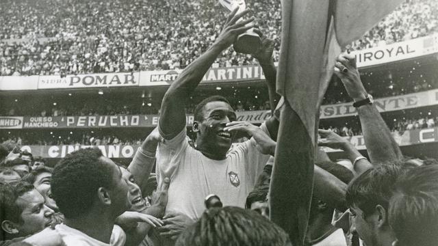 Le Brésilien Pelé soulevant le trophée Jules Rimet, après la victoire du Brésil à la coupe du monde au Mexique, le 21 juin 1970. [AP Photo/ Keystone - STF]