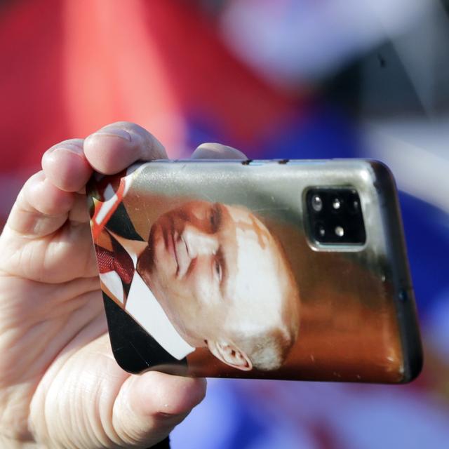 Un homme prend une photo avec un téléphone montrant une photo du président russe Vladimir Poutine lors d'une manifestation pro-russe à Belgrade, en Serbie, le 13 mars 2022. [EPA/KEYSTONE - Andrej Cukic]