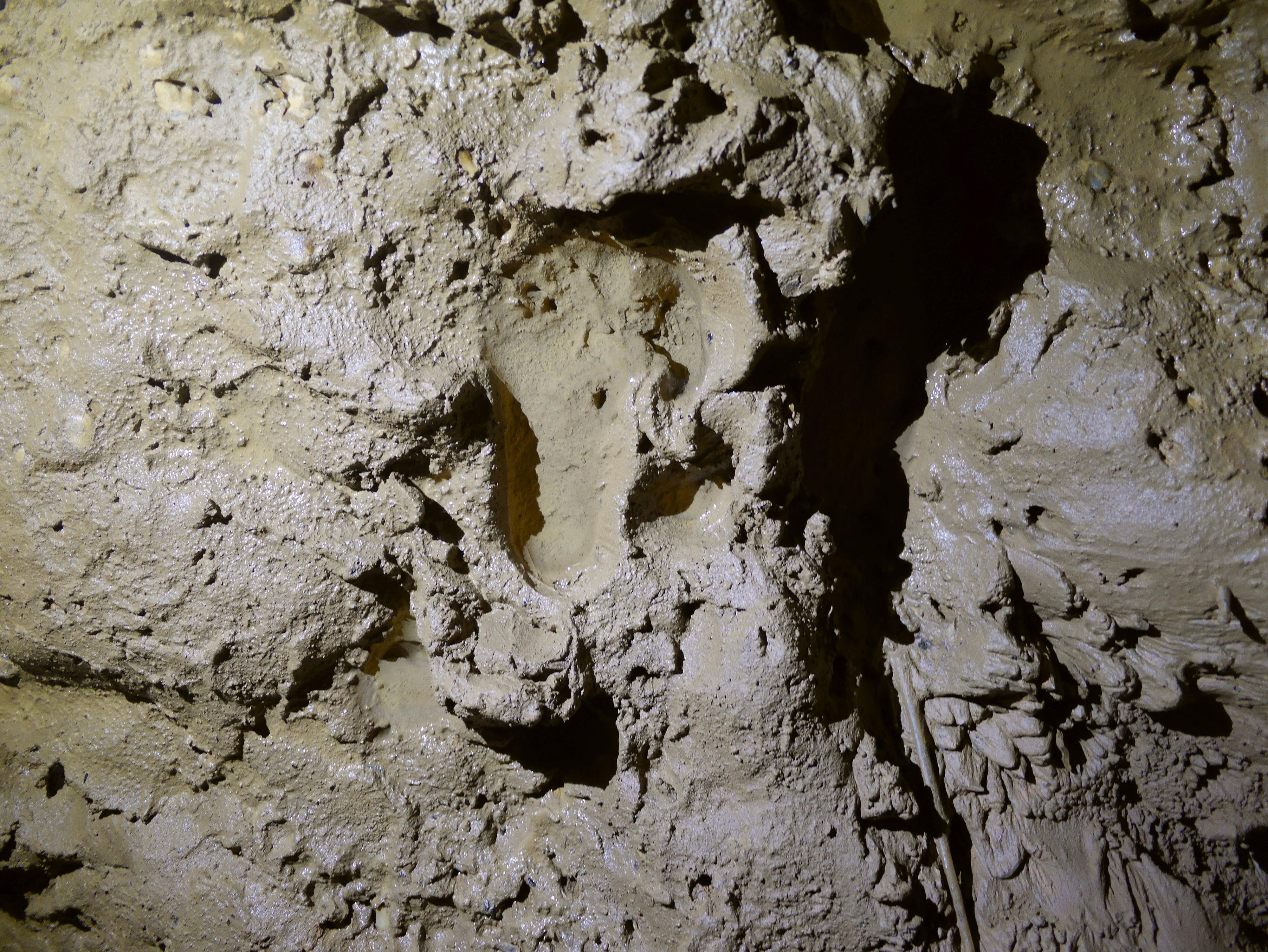 Une émouvante empreinte de pied nu d'enfant imprimée dans l'argile, dans le Réseau de la Licorne. [DRAC Nouvell-Aquitaine - Ph. Galant]