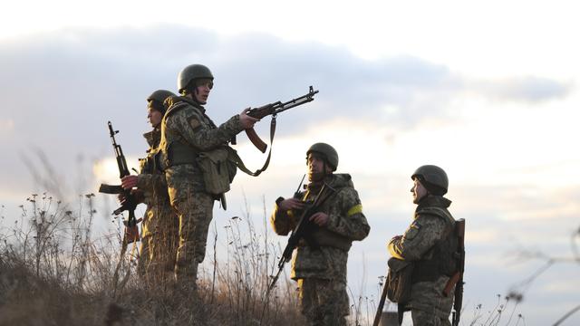 Des militaires ukrainiens prennent position pour défendre la capital Kiev contre l'agression russe. [EPA - Alisa Yakubovych - Keystone]