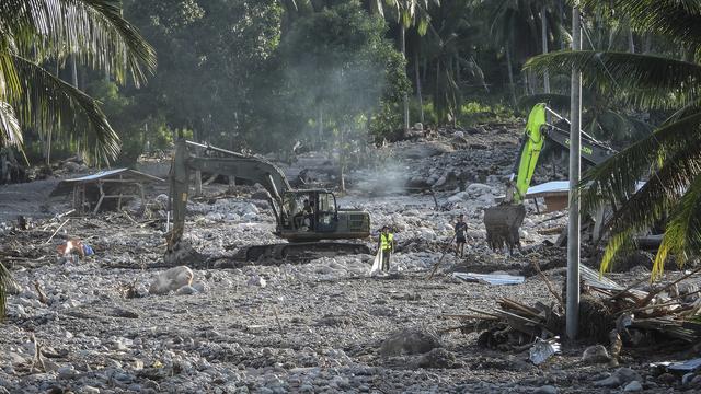 Les équipes de secours travaillent au milieu de la boue et des débris. [Keystone - AP Photo]