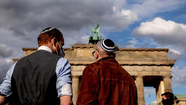 Des allemands juifs portant la kippa protestent contre l'antisémitisme dans le monde devant la porte de Brandenburg, à Berlin. [Keystone/EPA - Filip Singer]