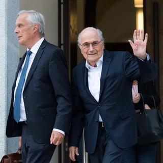 L'ancien président de la Fédération mondiale de football (Fifa), Joseph Blatter, à droite, et son avocat Lorenz Erni quittent le Tribunal pénal fédéral de Bellinzona, en Suisse, après le premier jour de son procès, mercredi 8 juin 2022. [KEYSTONE - Alessandro Crinari]