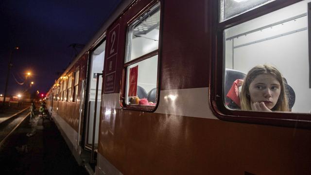 Une femme dans un train en Pologne après avoir fuit l'Ukraine. [AP Photo/Keystone - Visar Kryeziu]