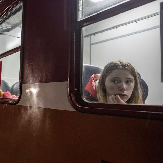 Une femme dans un train en Pologne après avoir fuit l'Ukraine. [AP Photo/Keystone - Visar Kryeziu]