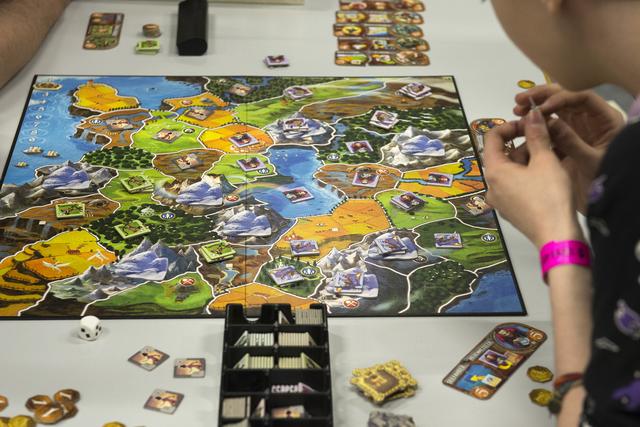 Des joueurs en pleine partie de "Smallworld". [Keystone - Georgios Kefalas]