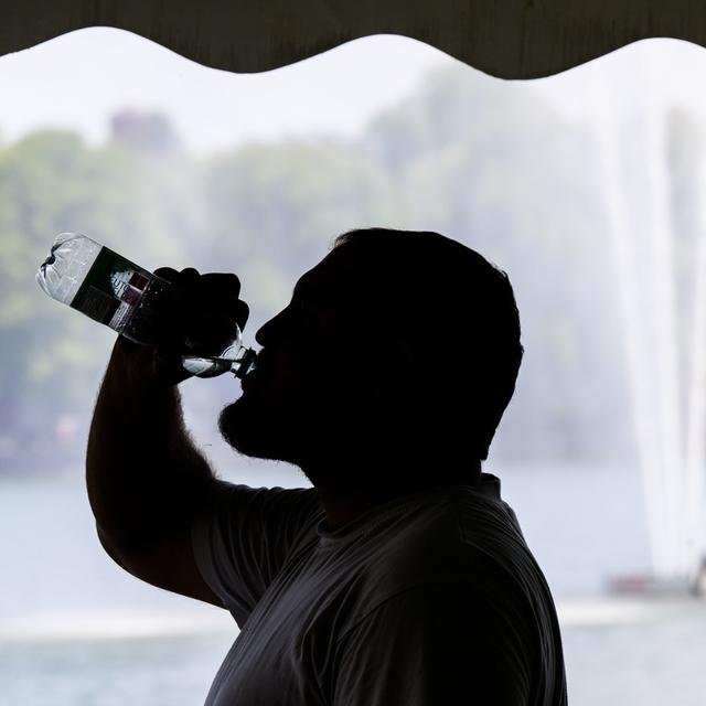 S'hydrater et rester à l'ombre pour lutter contre la canicule et la sécheresse. [Keystone - DPA/Julian Stratenschulte]