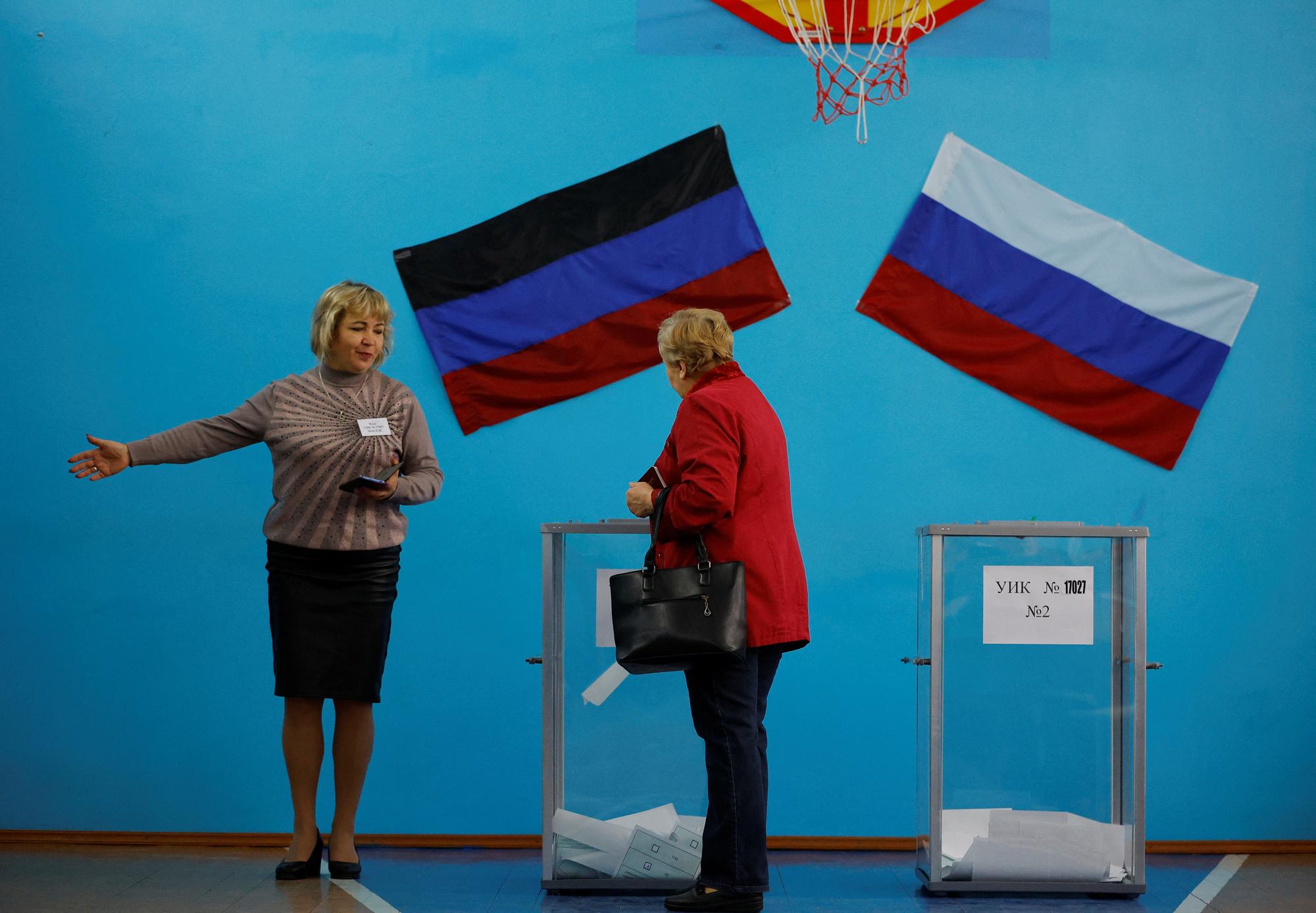 Une membre de la commission électorale montre la voie à un électeur dans un bureau de vote lors d'un référendum sur l'adhésion de la République populaire de Donetsk (RPD) autoproclamée à la Russie, à Donetsk. [reuters - Alexander Ermochenko]