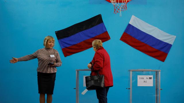 Une membre de la commission électorale montre la voie à un électeur dans un bureau de vote lors d'un référendum sur l'adhésion de la République populaire de Donetsk (RPD) autoproclamée à la Russie, à Donetsk. [reuters - Alexander Ermochenko]