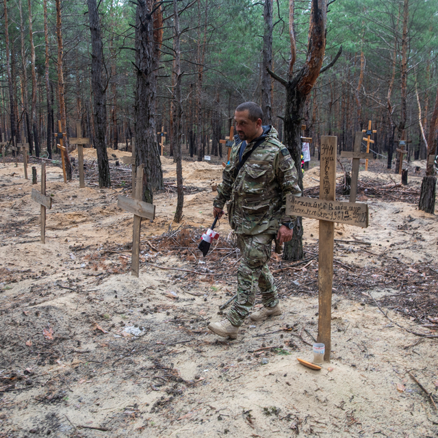 Un soldat ukrainien dans un cimetière improvisé à Izioum. [Reuters - Oleksandr Khomenko]