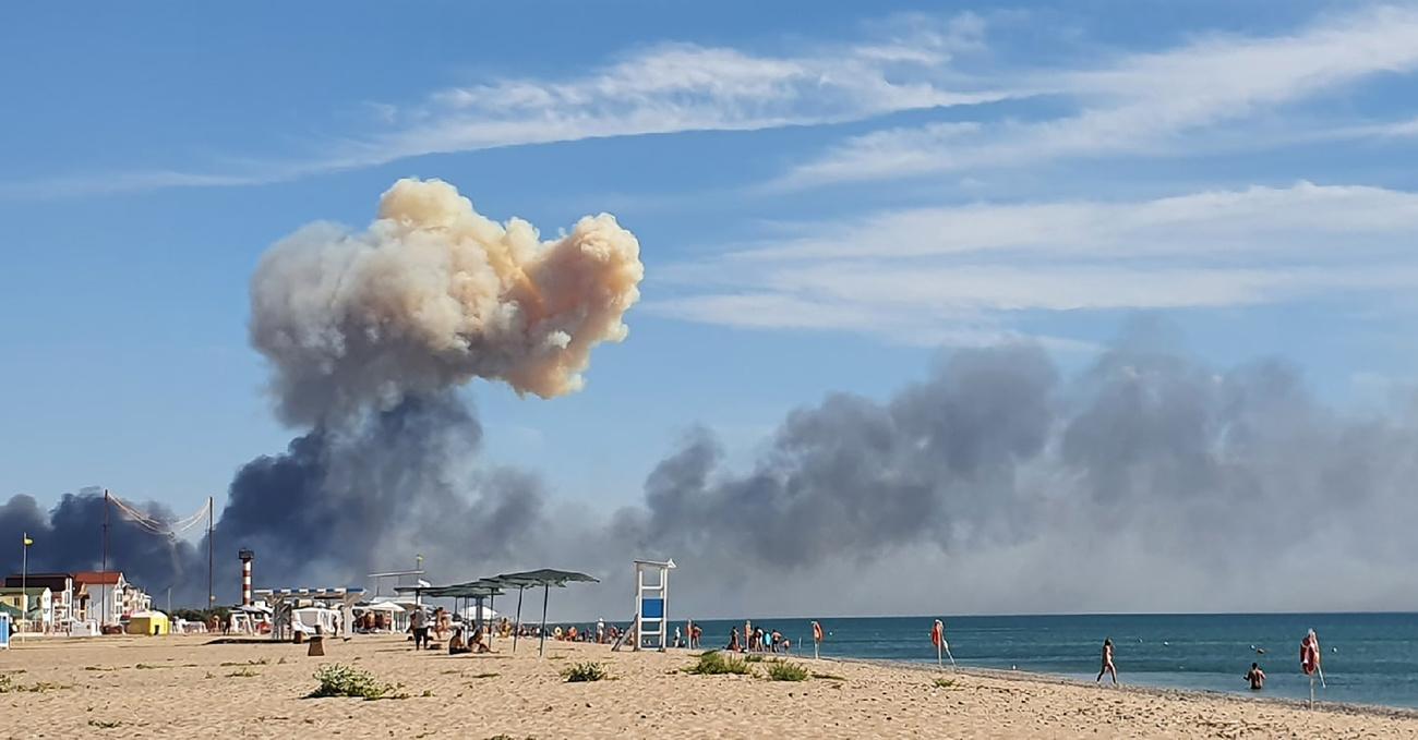 Une nuage de fumée aperçu depuis la plage de Saky, en Crimée, après que des explosions ont été entendues en provenance d'une base militaire aérienne russe. [Keystone - AP]