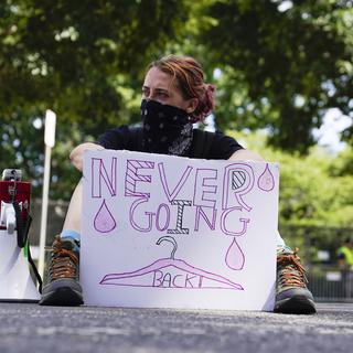 Une militante du droit à l'avortement lors des manifestations devant la Cour suprême des États-Unis avec une pancarte indiquant "Ne jamais revenir en arrière". [keystone - Mariam Zuhaib]