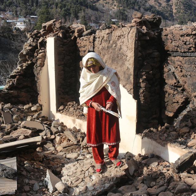 Une femme pakistanaise du Cachemire au milieu des débris de sa maison, détruite par les tirs transfrontaliers effectués par des militaires indiens, dans la vallée de Neelum, située sur la ligne de contrôle au Cachemire pakistanais, lundi 23 décembre 2019. [AP/Keystone - M.D. MUGHAL]
