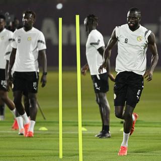 Le milieu de terrain sénégalais Cheikhou Kouyate (à droite) lors d'un entraînement à Doha. [AFP - Ozan Kose]