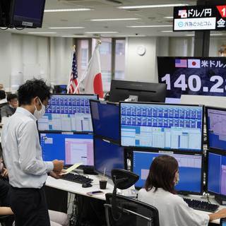 Les concessionnaires japonais au travail montrent le taux de change entre le yen japonais et le dollar américain, à Tokyo. [EPA/Keystone - Kimimasa Mayama]