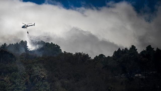 Un hélicoptère largue de l'eau sur un feu de forêt à Orjais, à Covilhã au Portugal, le 17 août 2022. [AFP - Patricia De Melo Moreira]