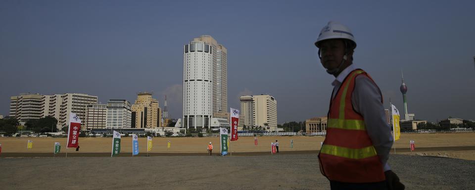 Un ouvrier chinois devant le chantier du Colombo Port City en 2018. [Keystone - AP Photo/Eranga Jayawardena, File]