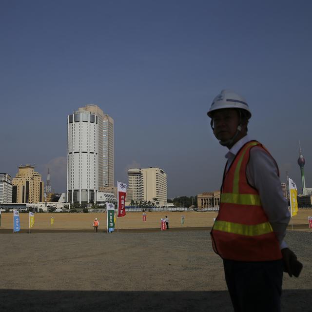 Un ouvrier chinois devant le chantier du Colombo Port City en 2018. [Keystone - AP Photo/Eranga Jayawardena, File]