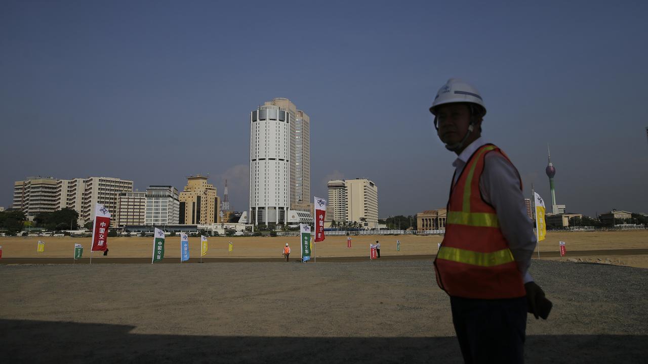 Un ouvrier chinois devant le chantier du Colombo Port City en 2018. [Keystone - AP Photo/Eranga Jayawardena, File]