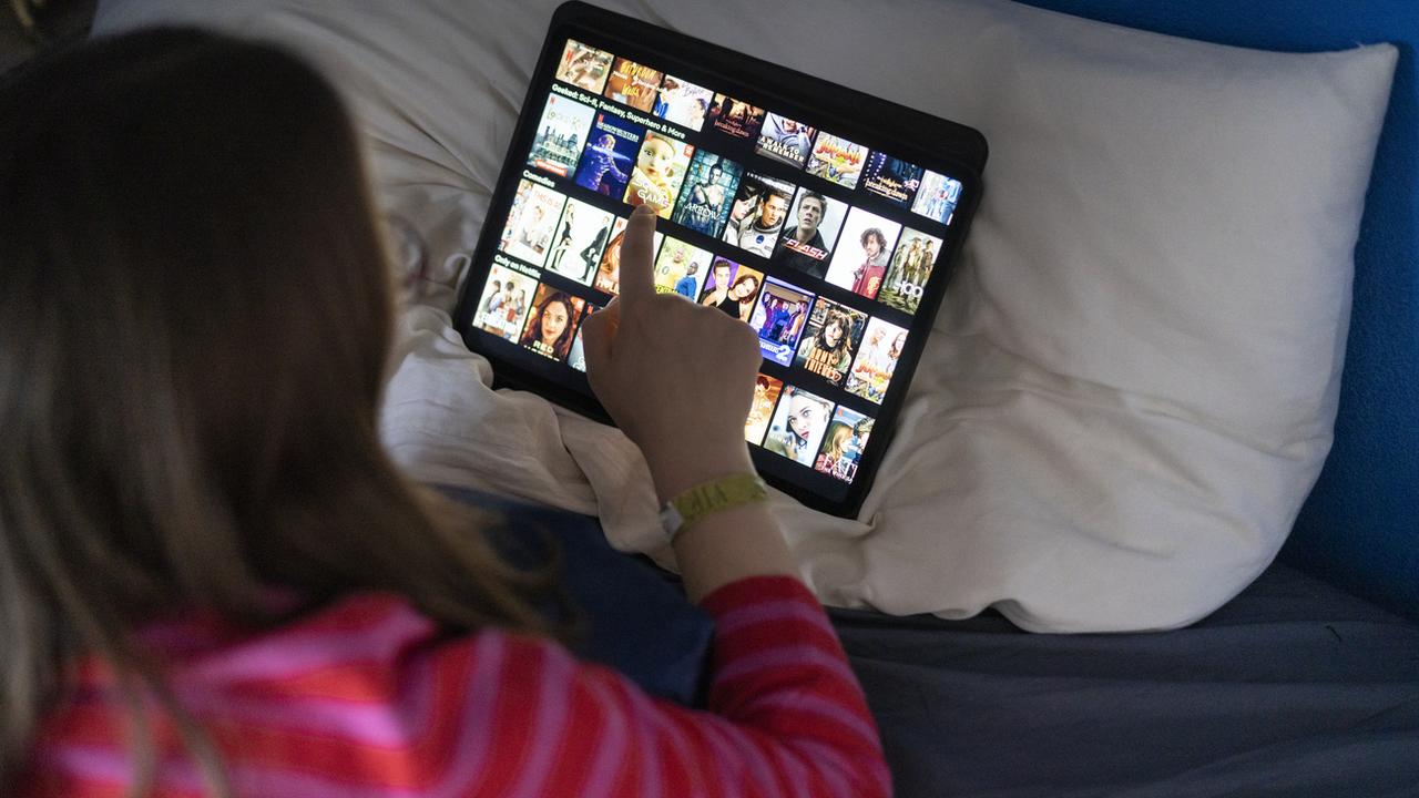 Une femme utilise la plateforme de streaming Netflix sur sa tablette. [Keystone - Gaëtan Bally]