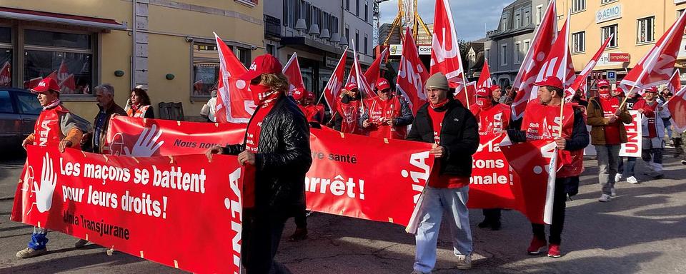 Comme dans plusieurs villes suisses ce lundi, les maçons en grève défilent dans les rues à Delémont. [RTS - Gaël Klein]