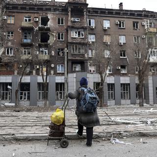 Un résident local regarde un immeuble d'habitation endommagé à Mariupol, en Ukraine, samedi 16 avril 2022. [AP Photo/KEYSTONE - Alexei Alexandrov]